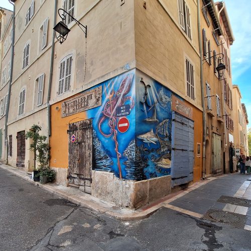 Réalisation de la fresque à l’aube de l’antiquité pour le restaurant corse « A Strega », dans le quartier du panier à Marseille. Fresque réalisée au mois d’octobre 2023, à l'aérosol. Street-Art et Graffiti.